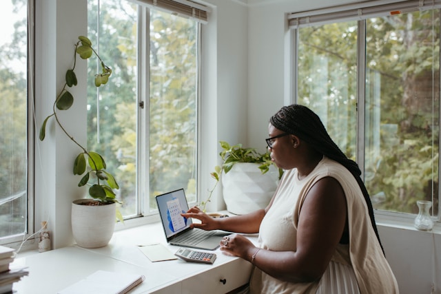 A woman in an ideal workstation, surrounded by home office essentials, working efficiently on her computer.